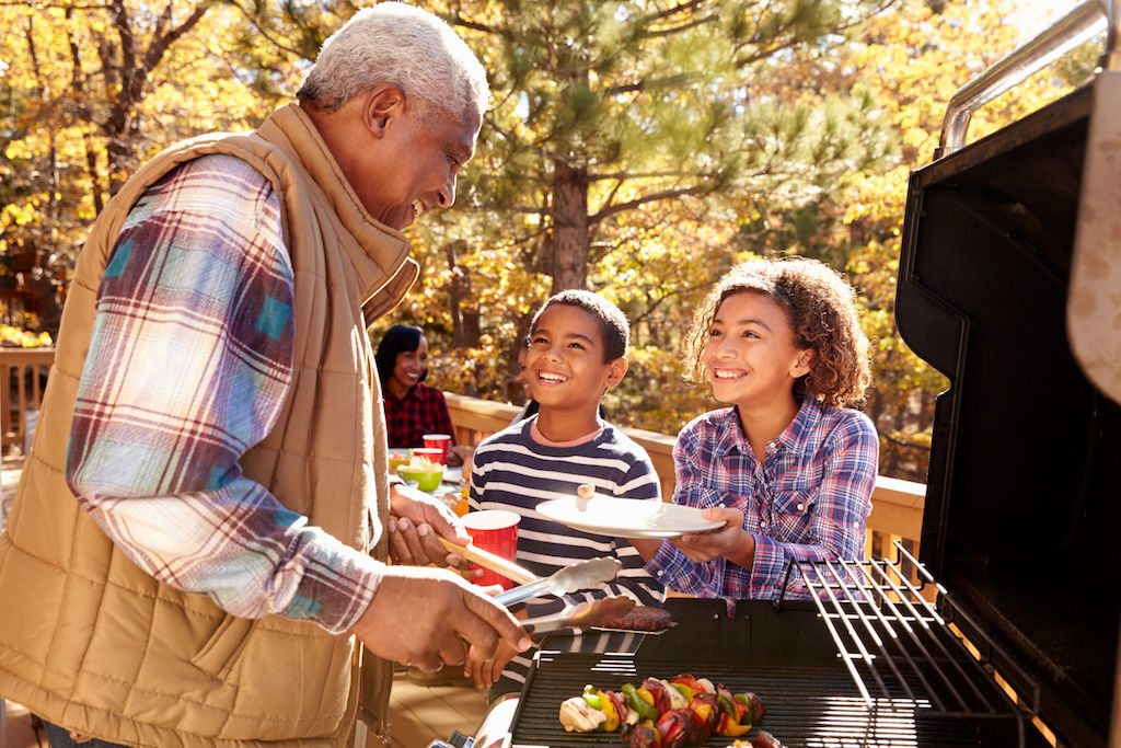 Grandfather grilling for his two grandkids